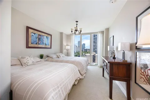 a bedroom with bed a chandelier and a window