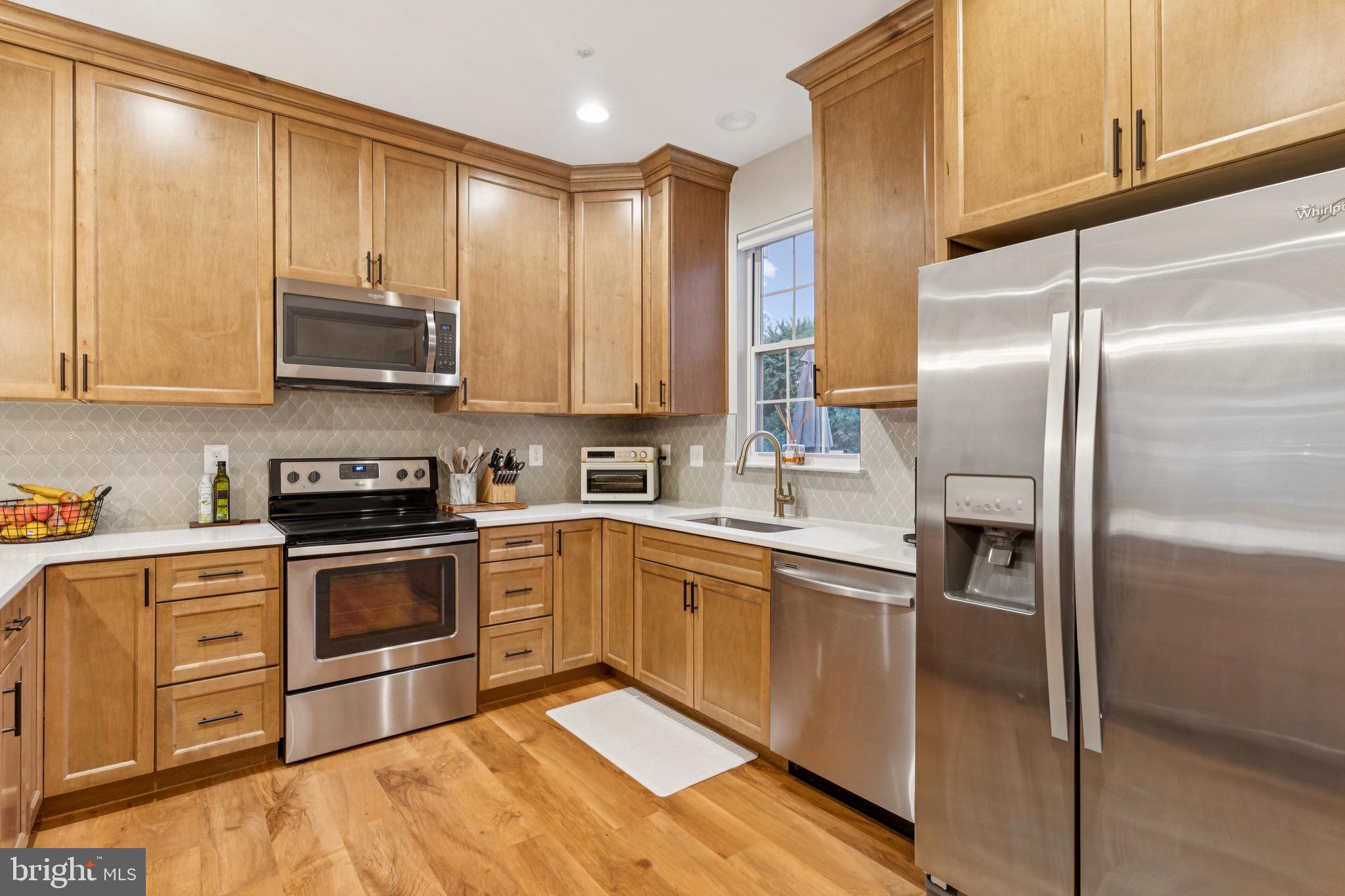 3844 Glebe Meadow Way Edgewater, MD 21037 - Photo 5 of 20 a kitchen with stainless steel appliances granite countertop a refrigerator a sink and white cabinets