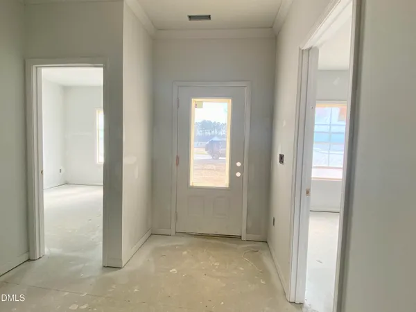 a view of an empty room with closet and a window