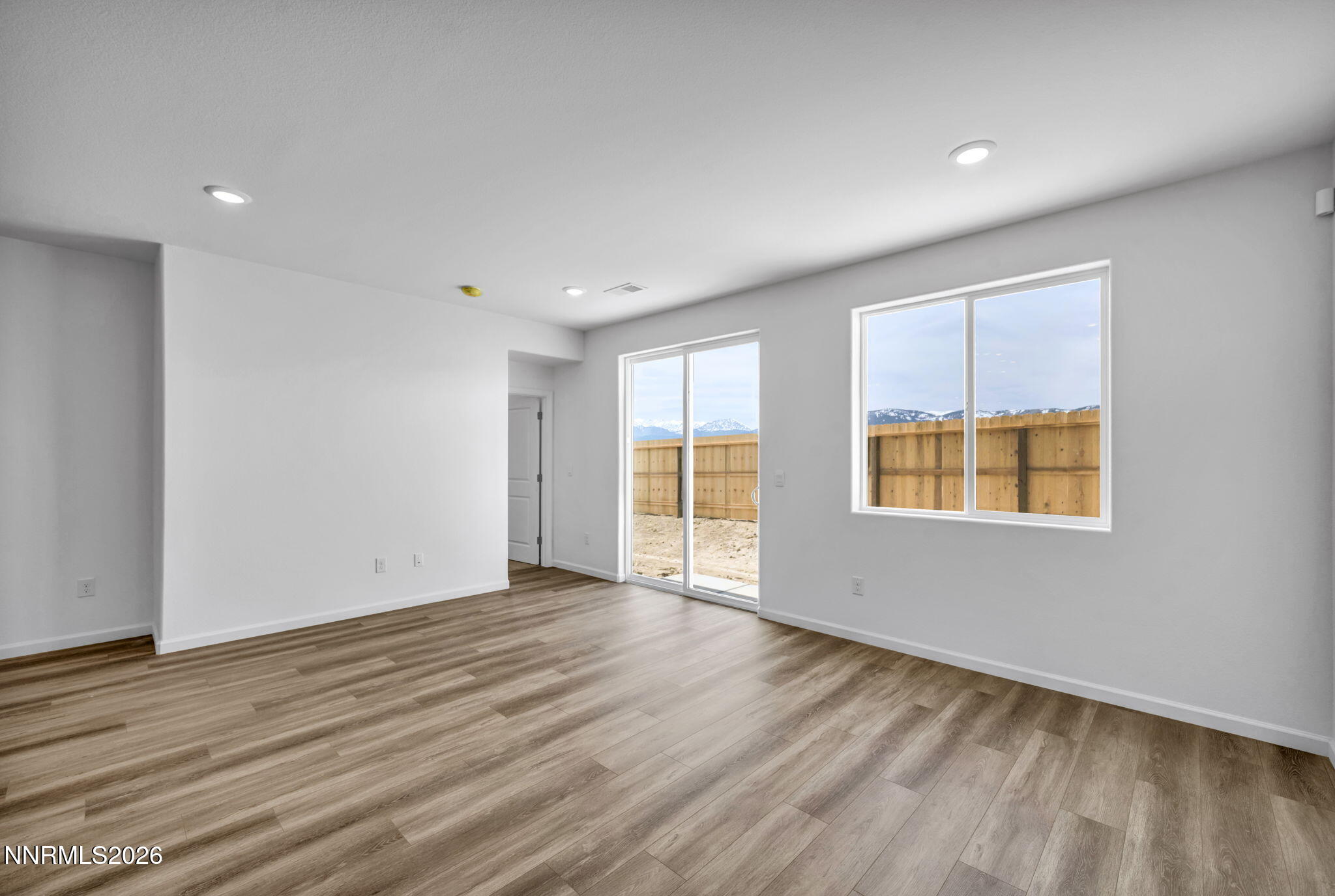 6676 Morgan Mill Road, Unit HOMESITE 14 Carson City, NV 89701 - Photo 9 of 24 a view of an empty room with wooden floor and a window