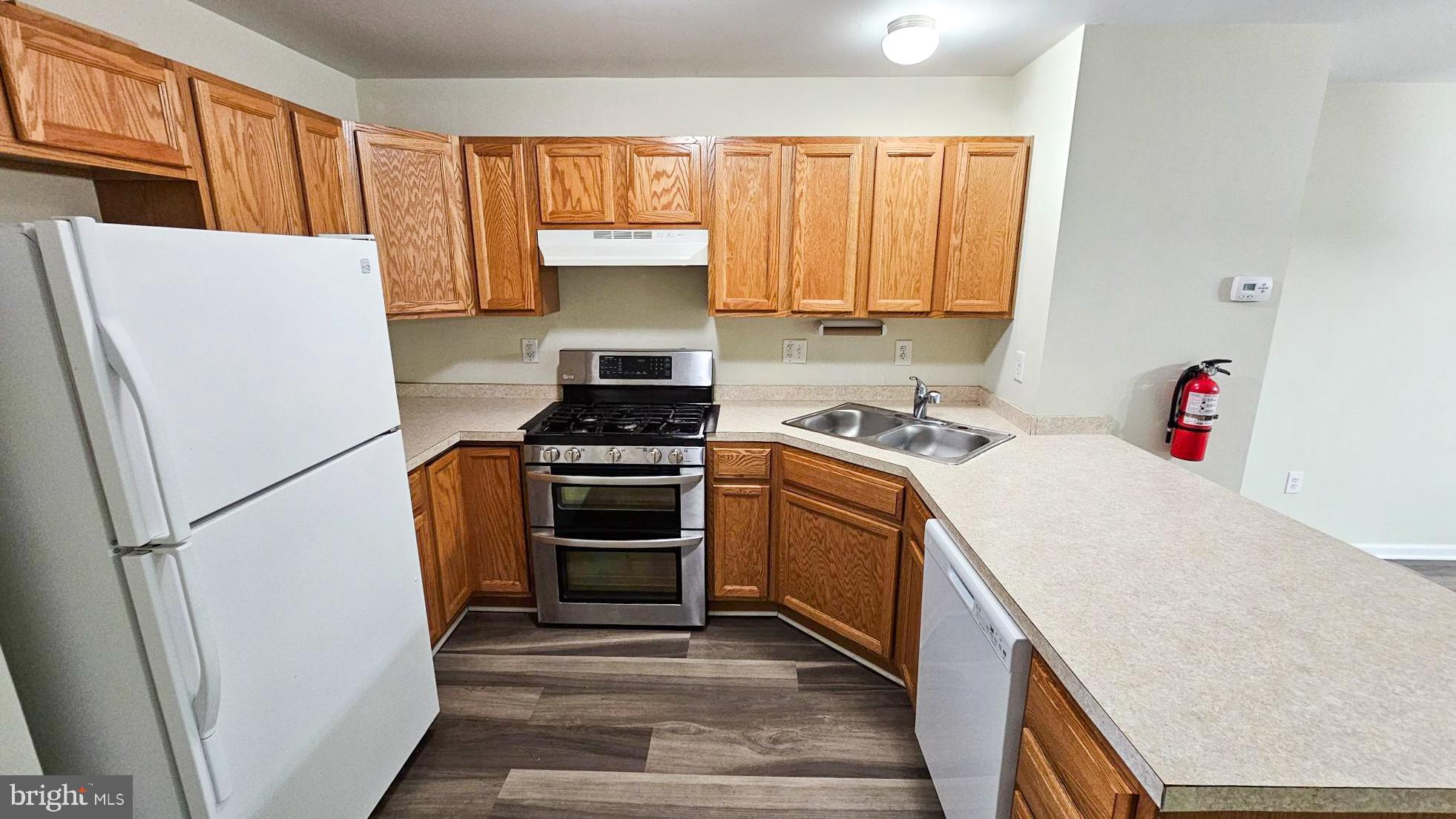 380 Radio Road, Unit B 6 Little Egg Harbor, NJ 08087 - Photo 4 of 33 a kitchen with a refrigerator a stove a sink dishwasher and cabinets with wooden floor