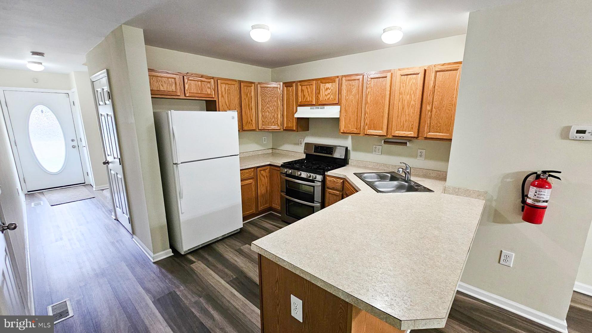 380 Radio Road, Unit B 6 Little Egg Harbor, NJ 08087 - Photo 5 of 33 a kitchen with a refrigerator a stove top oven a sink and wooden floor