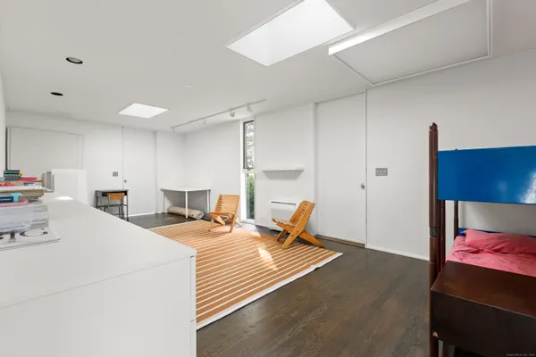 a bedroom with a bed lamp and a large window