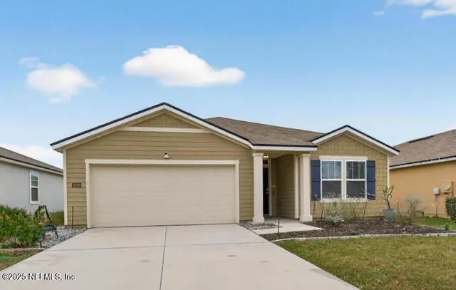 a front view of a house with a garden and yard