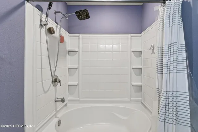 a bathroom with a sink toilet tub vanity and shower