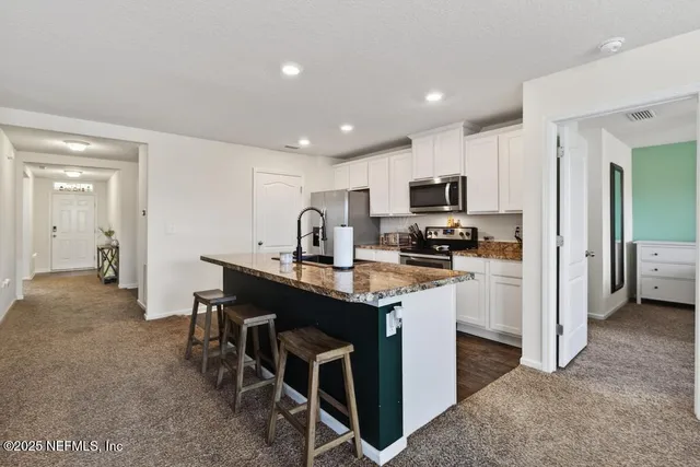 a kitchen island with granite countertop a sink and a stove