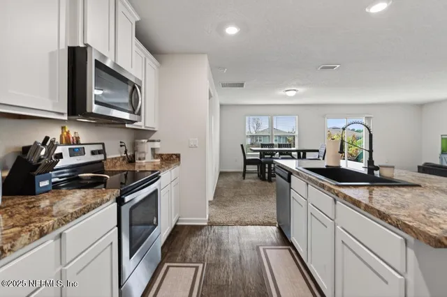 a kitchen with kitchen island granite counter tops and a stove