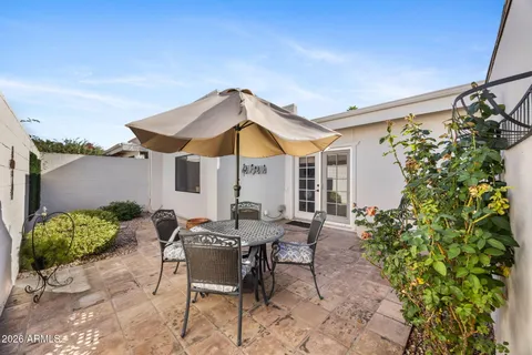a view of a patio with table and chairs under an umbrella