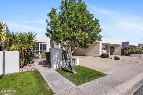 a view of a house with backyard and a tree