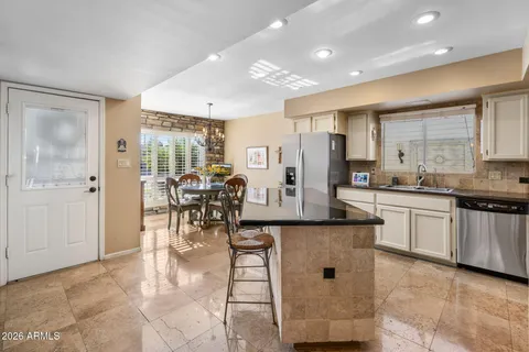 a kitchen with stainless steel appliances kitchen island granite countertop a stove a sink and a refrigerator