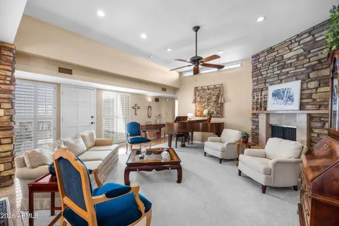 a living room with furniture a fireplace and a chandelier