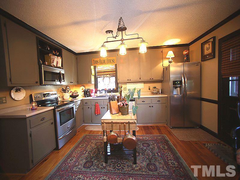 6216 Wynbrook Way Raleigh, NC 27612 - Photo 7 of 19 a kitchen with granite countertop a refrigerator stove top oven and sink
