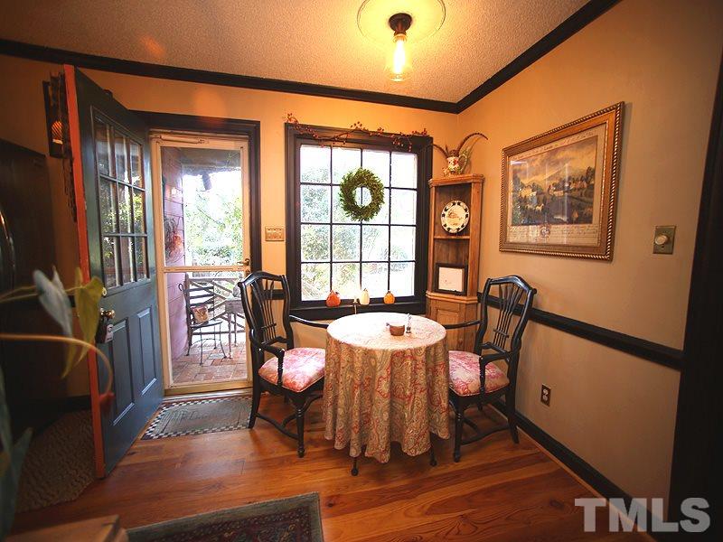 6216 Wynbrook Way Raleigh, NC 27612 - Photo 8 of 19 a view of a dining room with furniture a chandelier and wooden floor