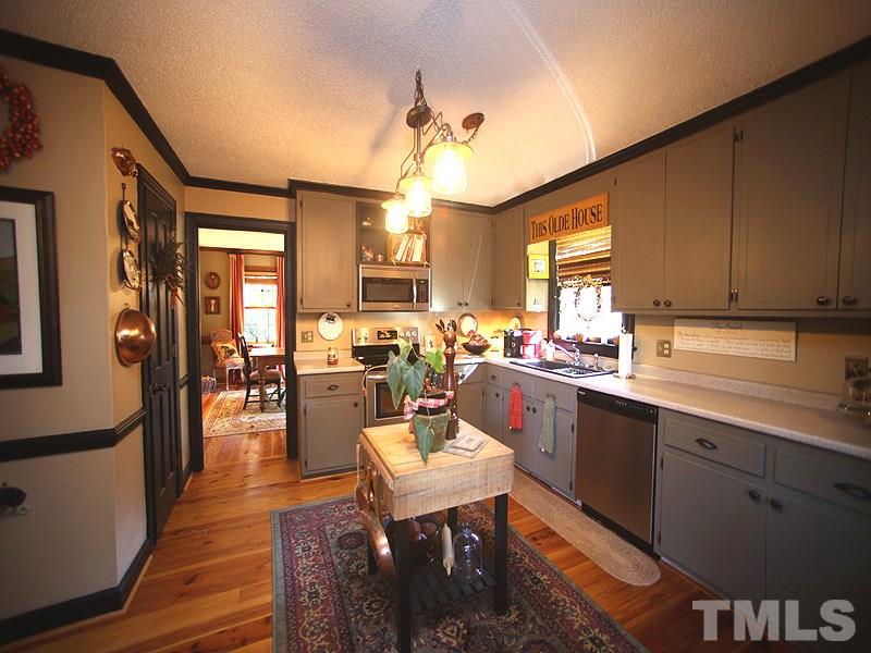 6216 Wynbrook Way Raleigh, NC 27612 - Photo 9 of 19 a kitchen with a dining table chairs sink and granite counter tops