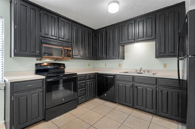a kitchen with granite countertop cabinets stainless steel appliances and a sink