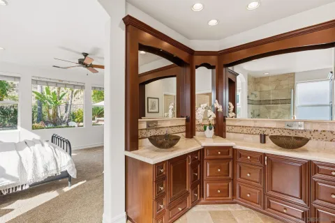 a bathroom with a sink a mirror and next to a window