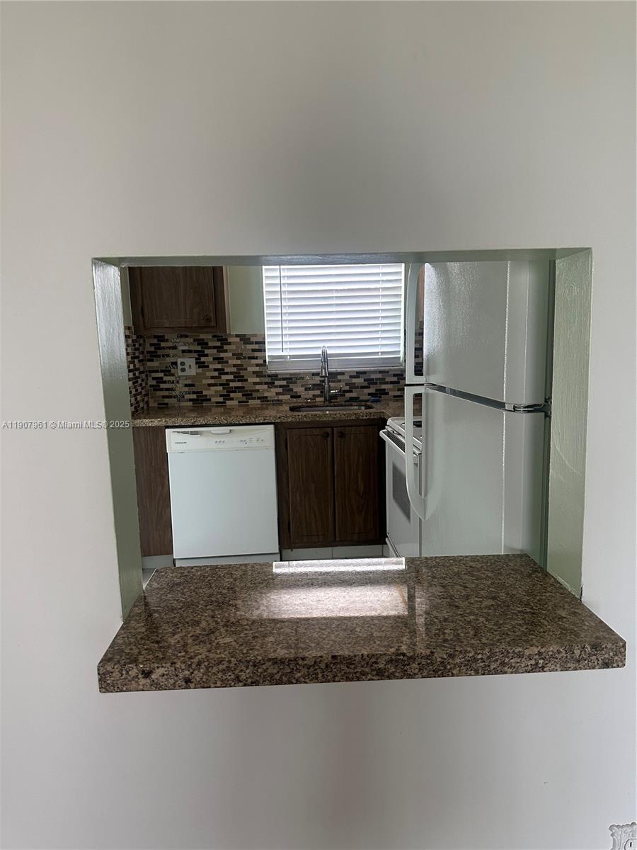 8110 Sunrise Lakes Boulevard, Unit 304 Sunrise, FL 33322 - Photo 8 of 9 a kitchen with a sink stove and refrigerator