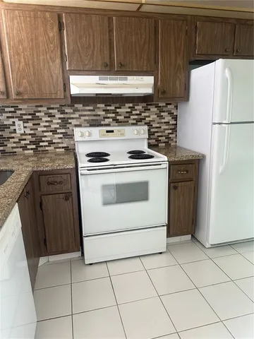 a kitchen with cabinets and white appliances