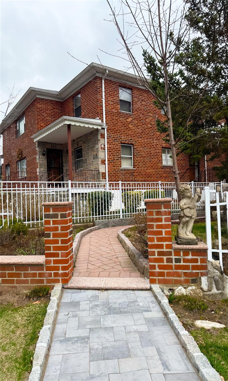 View of front of property featuring brick siding and a fenced front yard