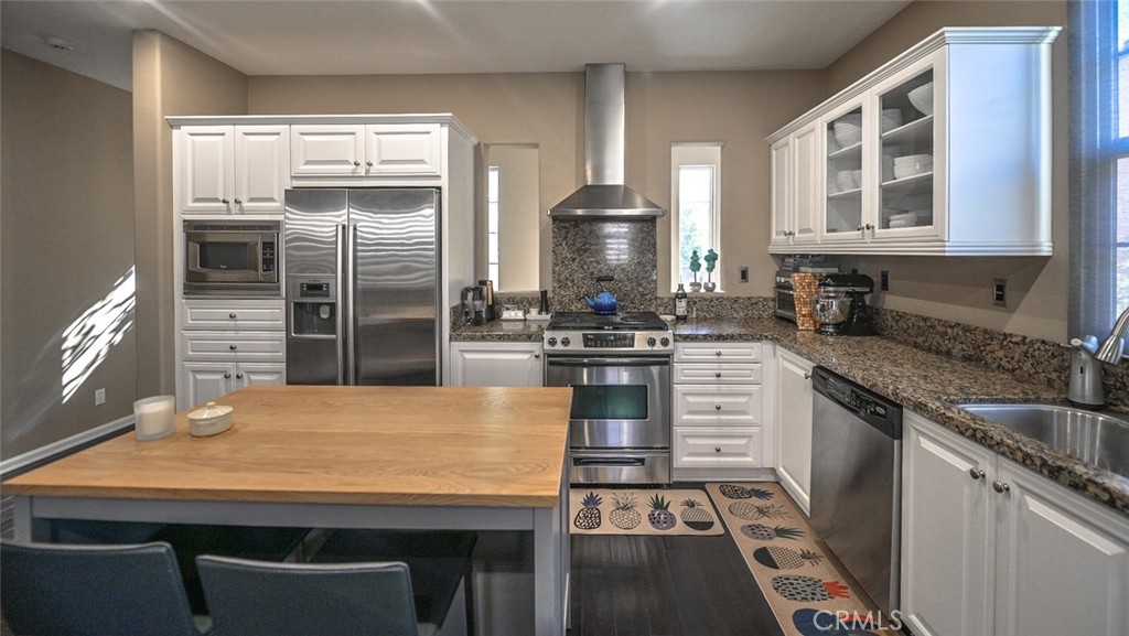 64 Scarlet Bloom Irvine, CA 92618 - Photo 8 of 22 a kitchen with stainless steel appliances granite countertop a stove a sink and a refrigerator