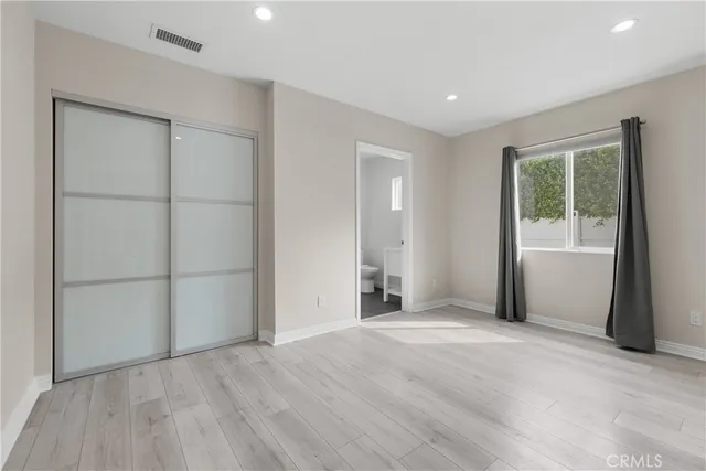 an empty room with windows and closet