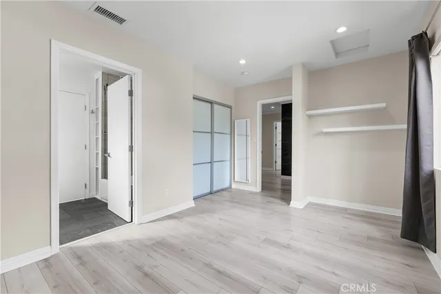an empty room with closet and wooden floor