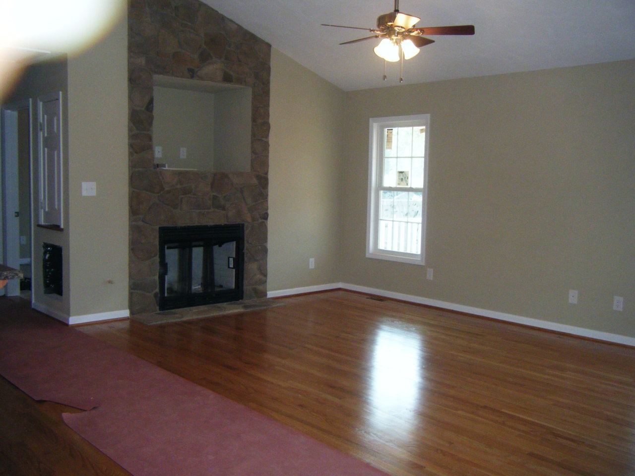 3 Goodview Road Goodview, VA 24095 - Photo 3 of 7 a view of an empty room with wooden floor fireplace and a window