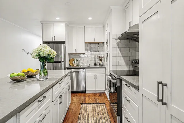 a kitchen with kitchen island granite countertop a sink stainless steel appliances and cabinets