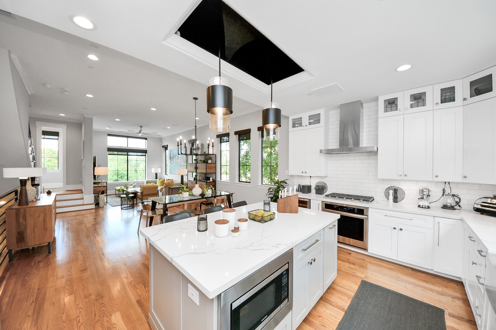 2765 Freund Street Houston, TX 77003 - Photo 17 of 44 a large white kitchen with a stove a sink a dishwasher and cabinets with wooden floor