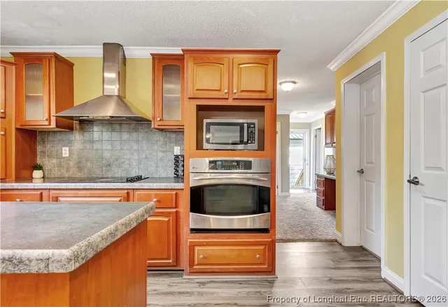 a kitchen with granite countertop a stove and a wooden floor