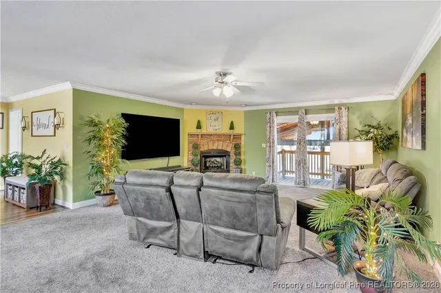 a living room with furniture a flat screen tv and a fireplace