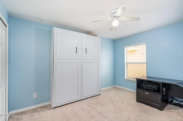 a livingroom with a ceiling fan and window