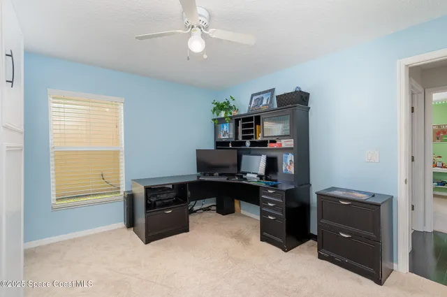 a view of a workspace with furniture and a window