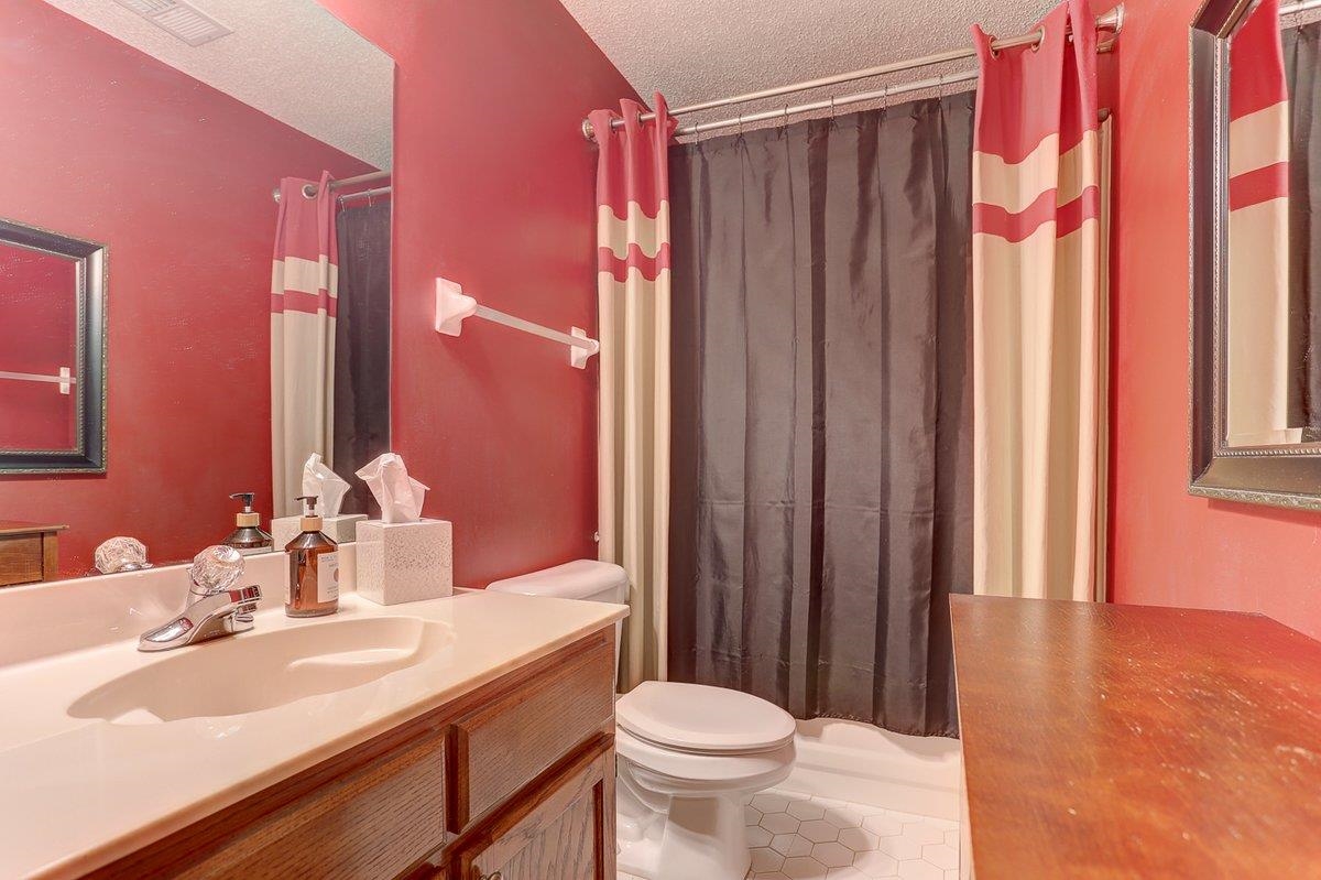 3365 Harrell Road Arlington, TN 38002 - Photo 25 of 36 a bathroom with a sink a toilet a mirror and shower curtain