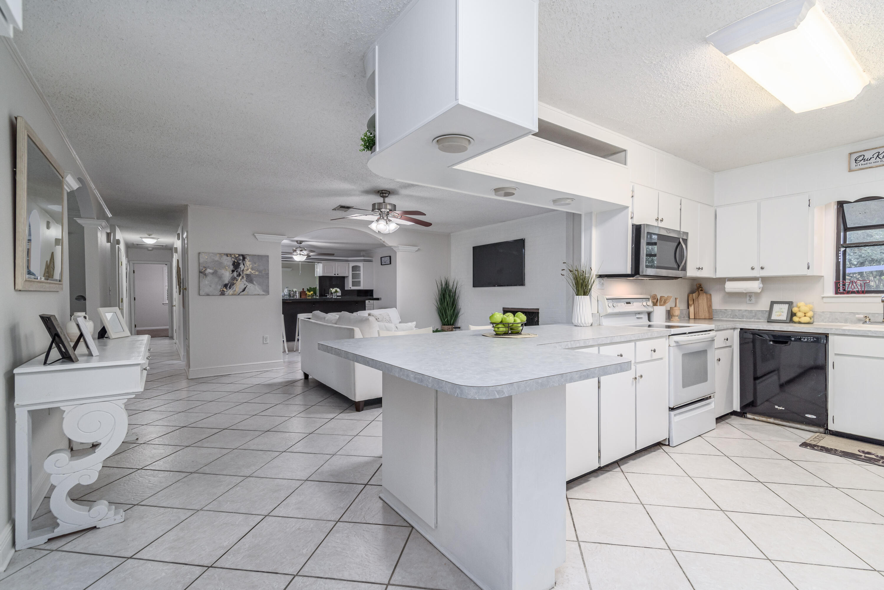 207 Country Club Road Shalimar, FL 32579 - Photo 17 of 60 a kitchen with kitchen island granite countertop a sink counter top space appliances and cabinets