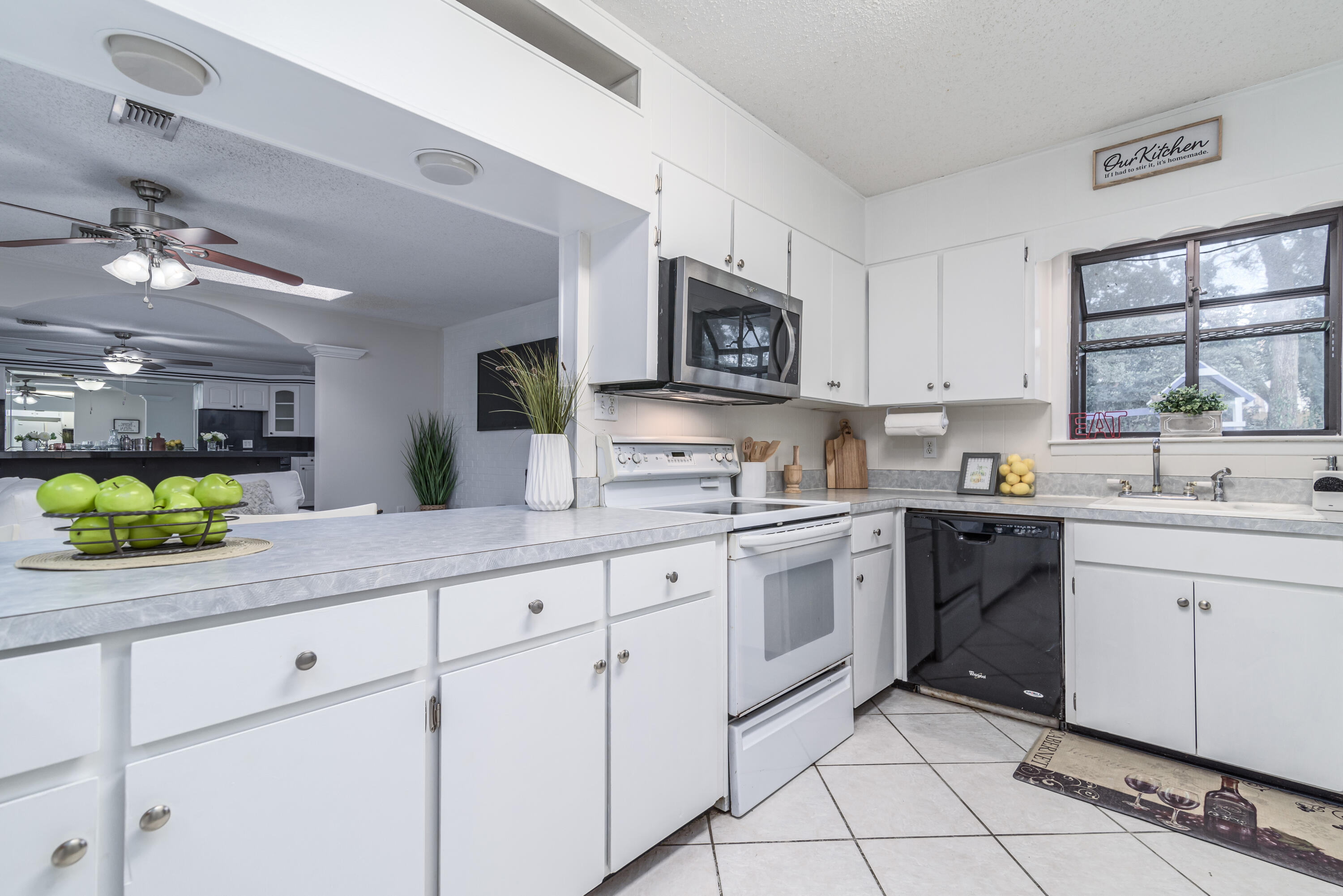207 Country Club Road Shalimar, FL 32579 - Photo 18 of 60 a kitchen with white cabinets and appliances