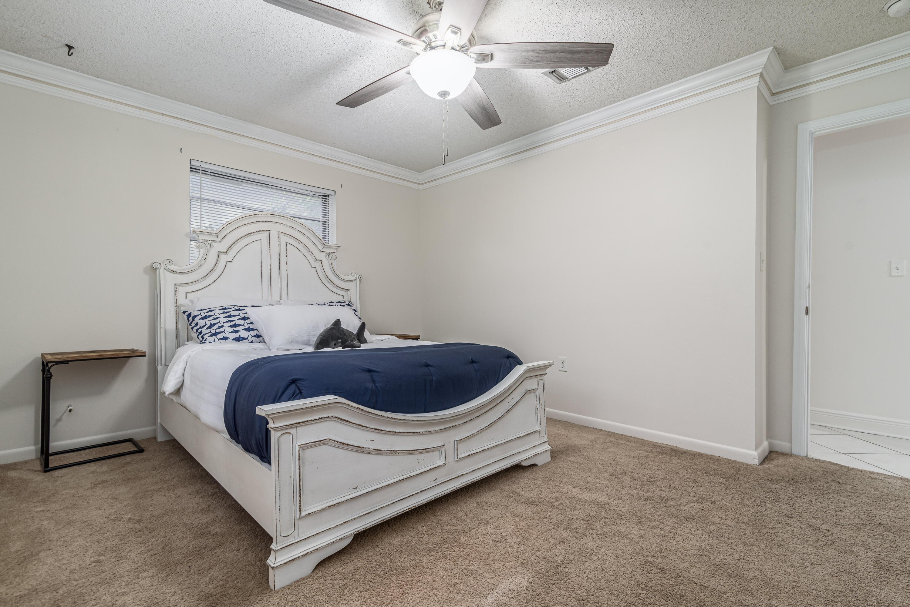 207 Country Club Road Shalimar, FL 32579 - Photo 44 of 60 a spacious bedroom with a bed and a chandelier