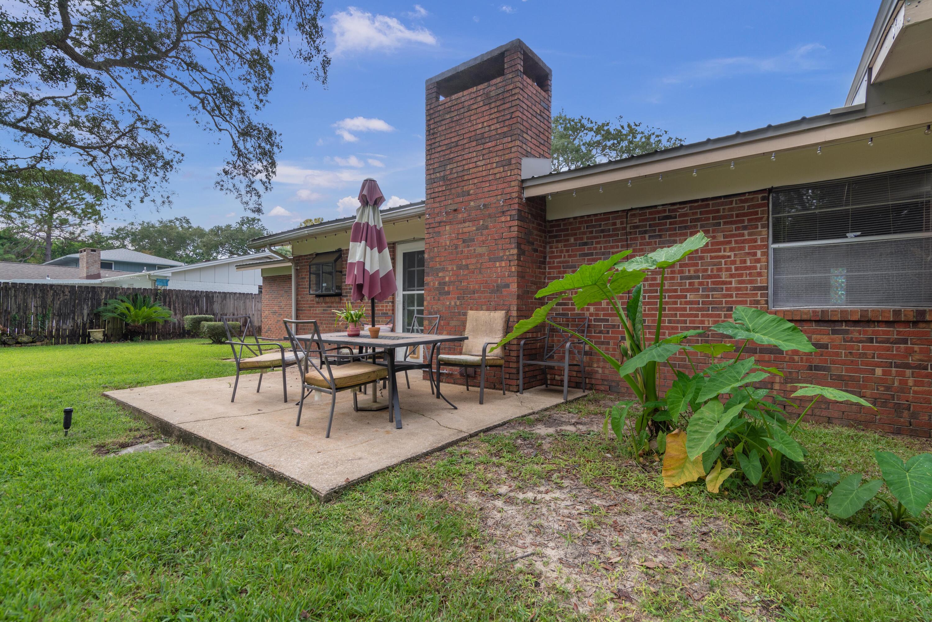 207 Country Club Road Shalimar, FL 32579 - Photo 59 of 60 a view of a patio with a table and chairs