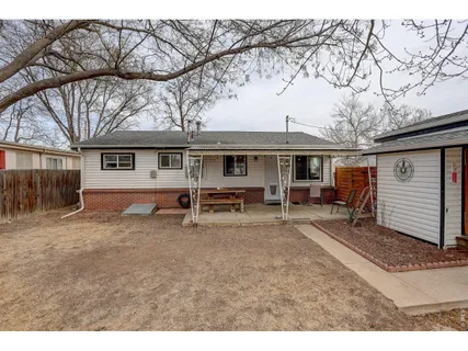 a view of a house with a yard and wooden fence