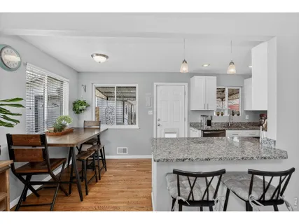 a kitchen with stainless steel appliances granite countertop a table chairs and a refrigerator
