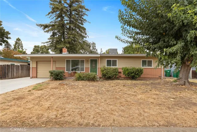 a front view of house with yard and trees around