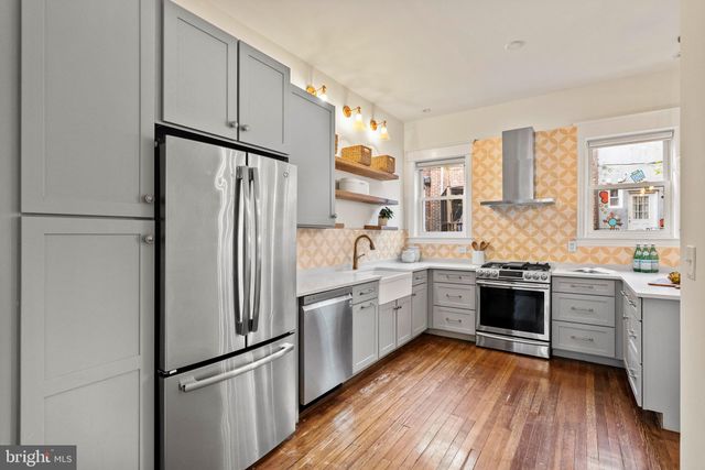 a kitchen with sink a stove and chairs