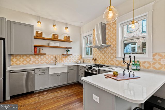 a kitchen with stainless steel appliances granite countertop a refrigerator and a stove top oven