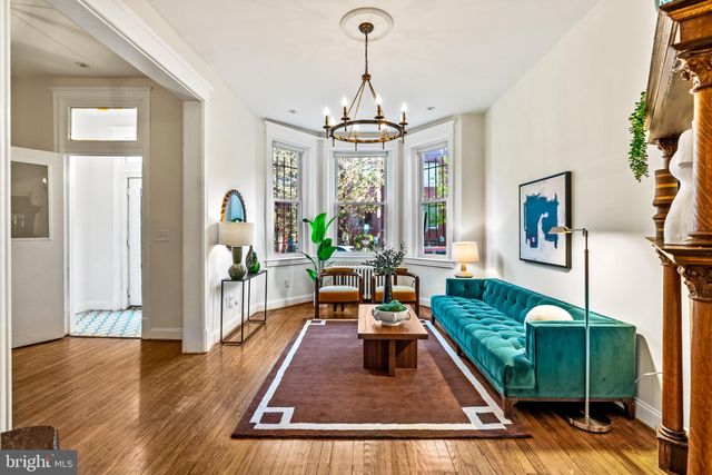 a view of a dining room with furniture a chandelier and wooden floor