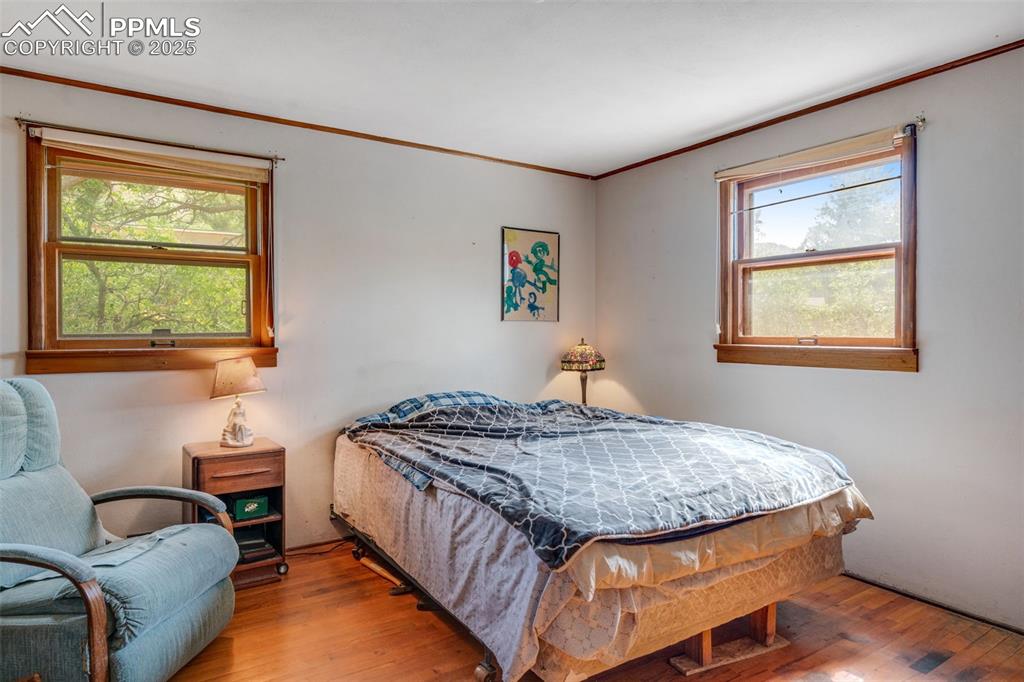4415 Heizer Street Cascade, CO 80809 - Photo 19 of 50 Bedroom featuring original wood flooring, ornamental molding and 2 windows for lots of natural light