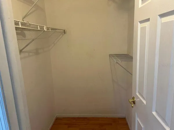a view of an empty room with window chandelier fan and fire place