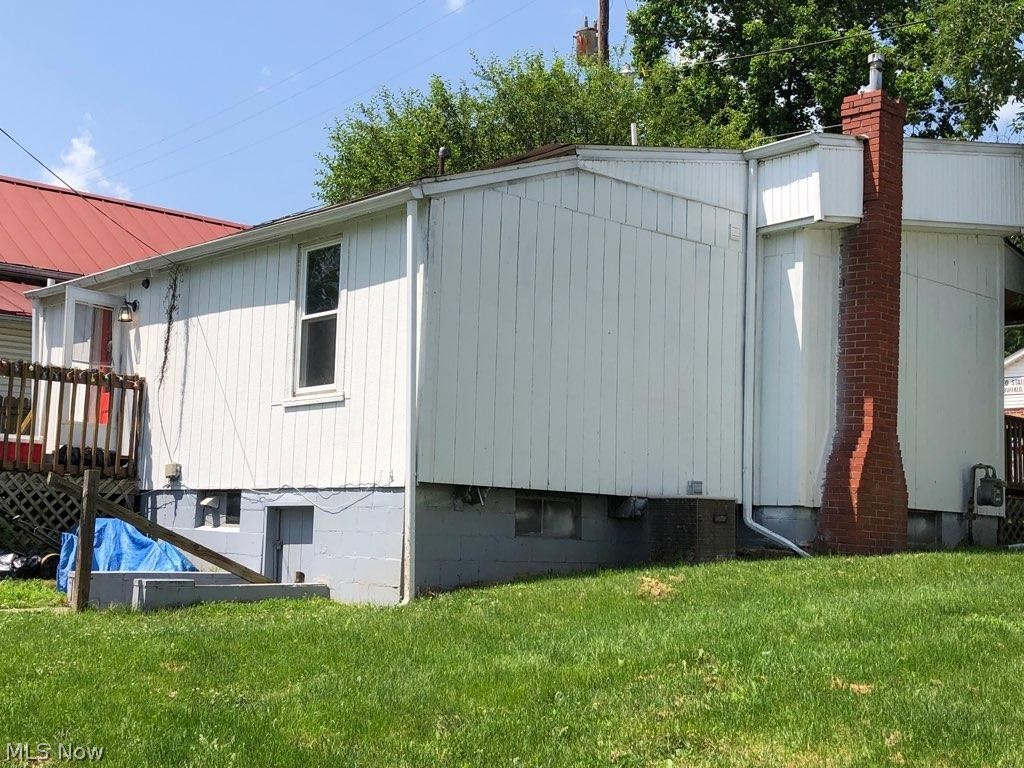 11978 Clay Pike Road Buffalo, OH 43772 - Photo 5 of 6 View of property exterior featuring a lawn and a chimney
