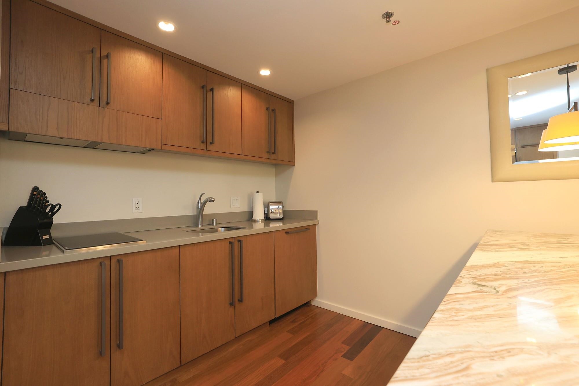 1 Ritz Carlton Drive, Unit 1502 Lahaina, HI 96761 - Photo 15 of 47 a kitchen with stainless steel appliances granite countertop a sink dishwasher stove and cabinets with wooden floor