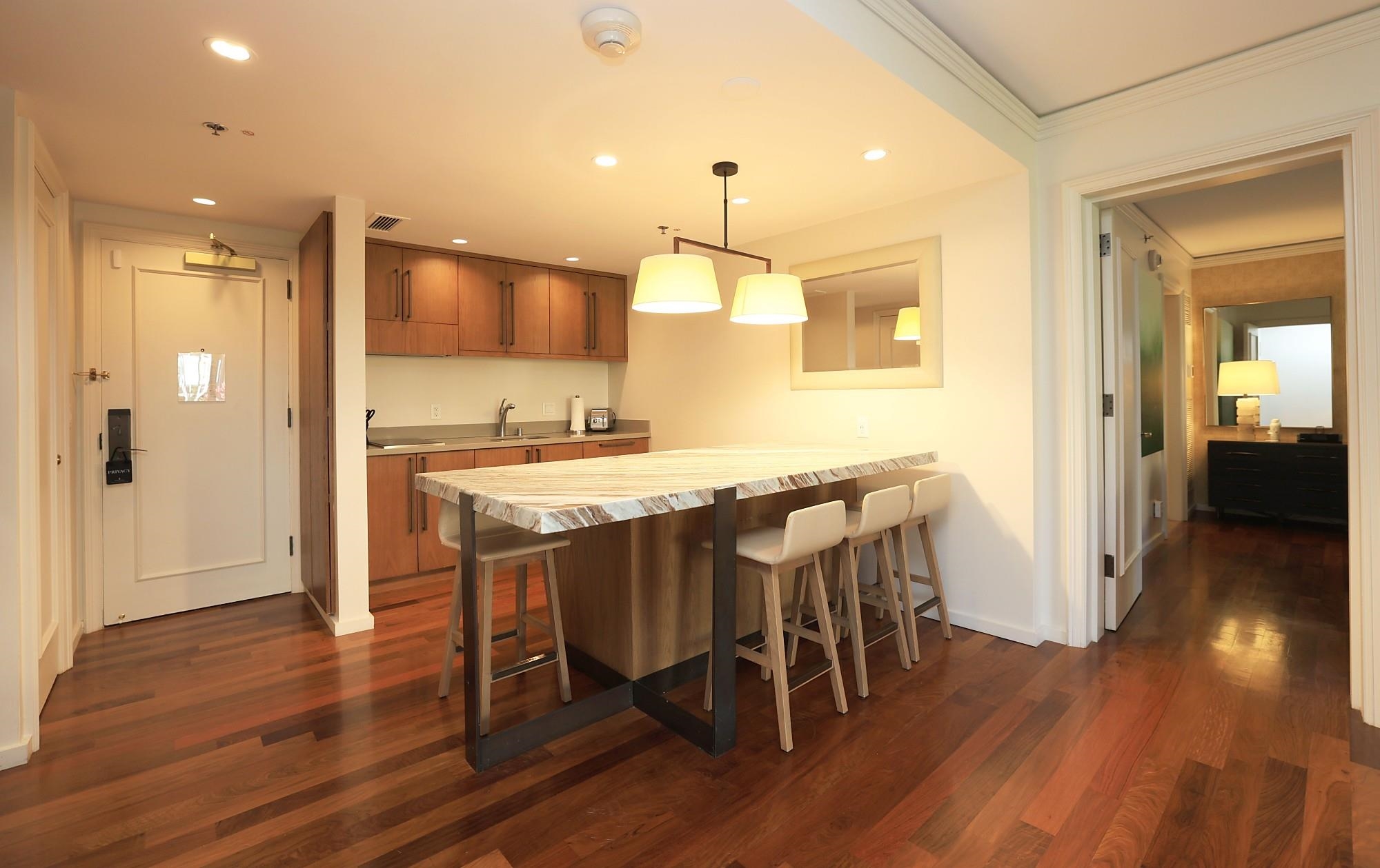 1 Ritz Carlton Drive, Unit 1502 Lahaina, HI 96761 - Photo 4 of 47 a kitchen with kitchen island granite countertop a sink cabinets and wooden floor