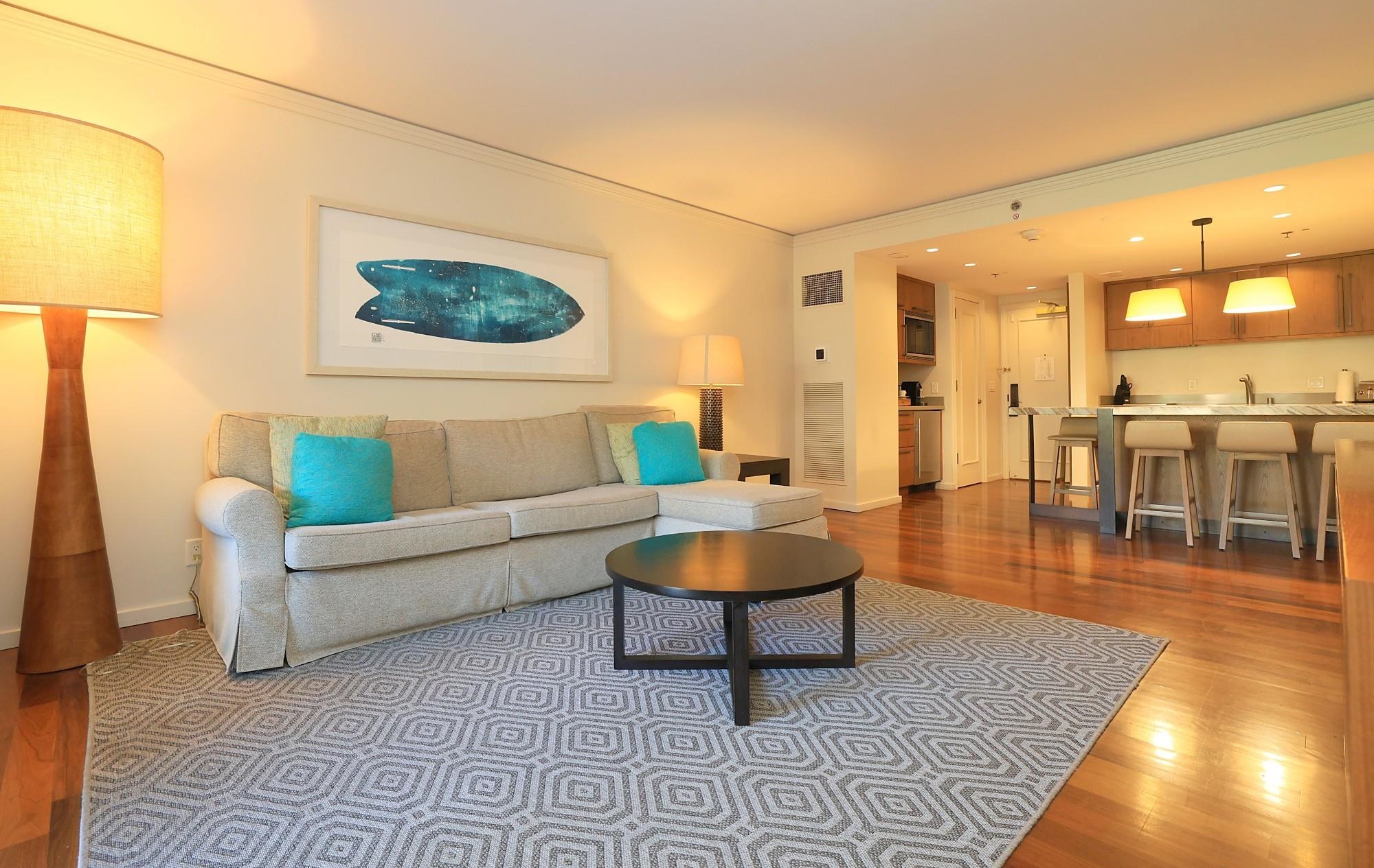 1 Ritz Carlton Drive, Unit 1502 Lahaina, HI 96761 - Photo 7 of 47 a living room with couches and a dining table with wooden floor